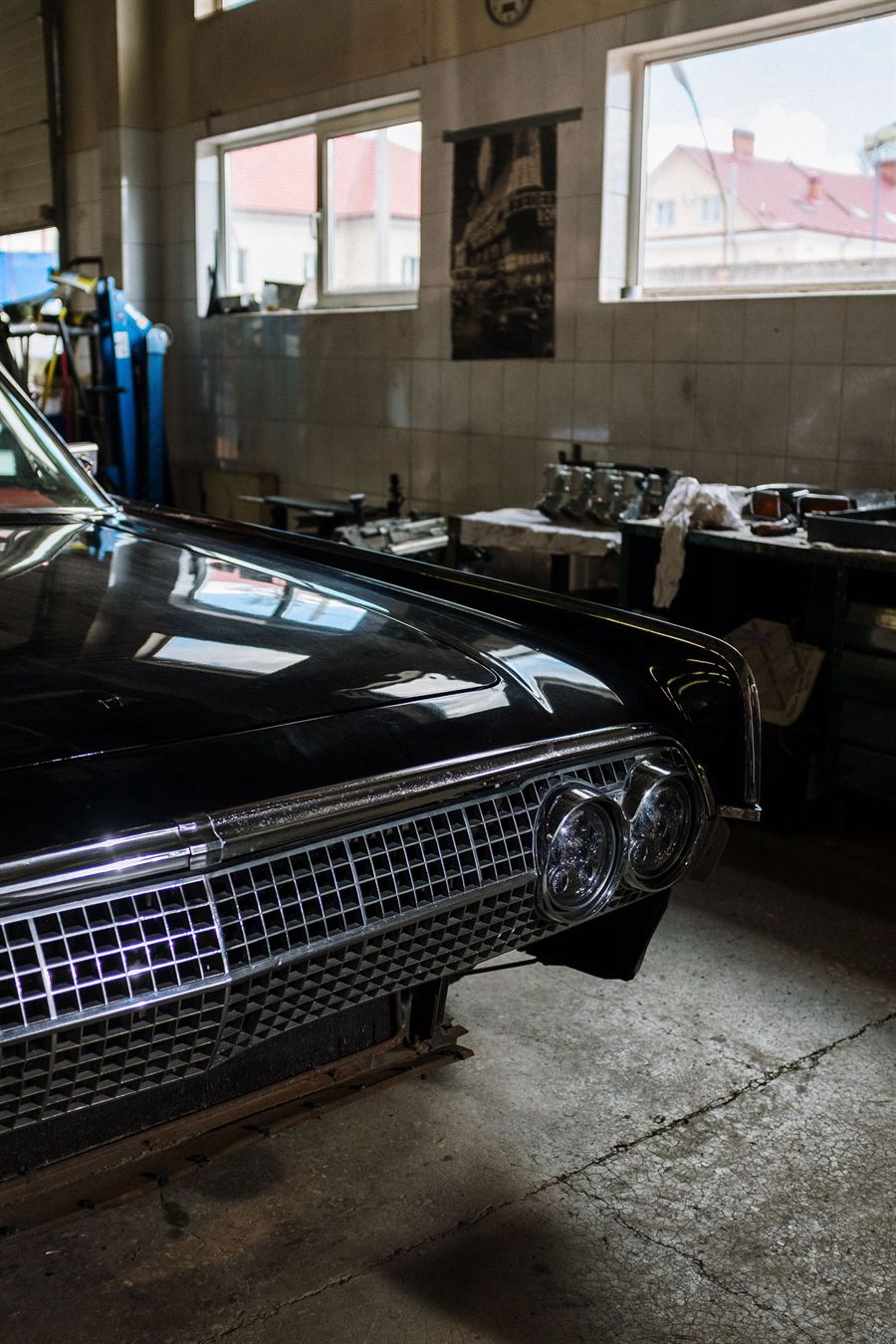A car parked nose first in a workshop bay, ready to be collected.